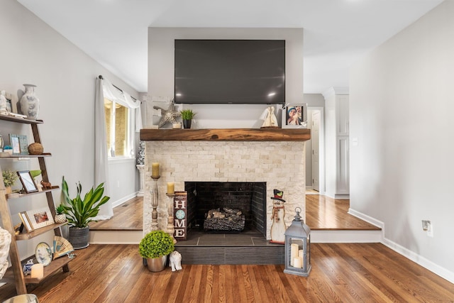 living room with hardwood / wood-style flooring and a tiled fireplace