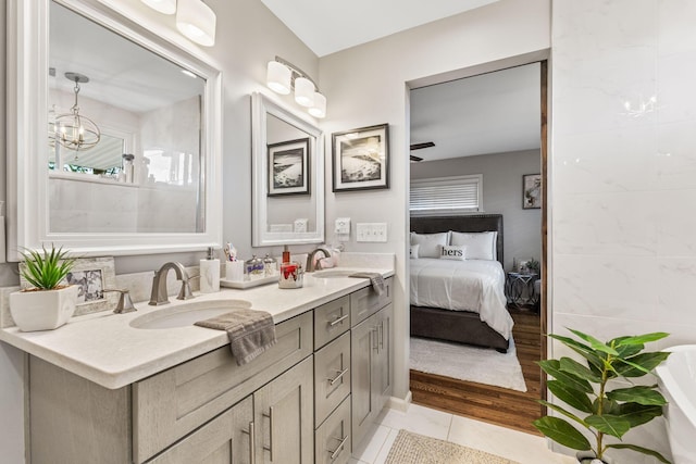 bathroom featuring tile patterned flooring, vanity, a healthy amount of sunlight, and ceiling fan with notable chandelier