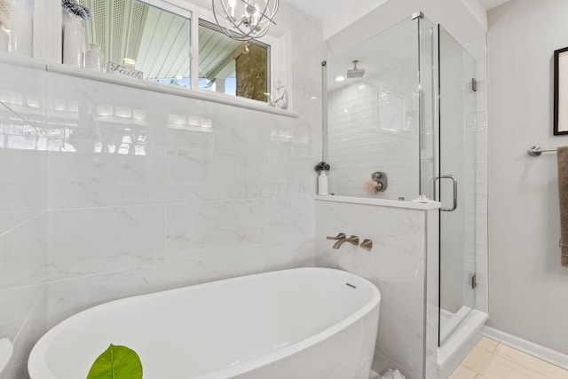 bathroom featuring tile patterned flooring, independent shower and bath, and tile walls