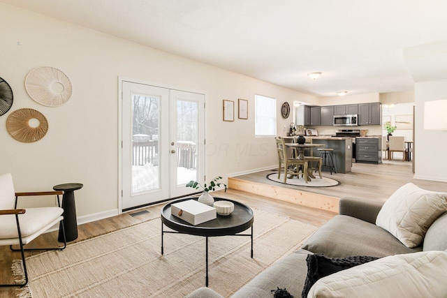 living room with french doors and light hardwood / wood-style flooring