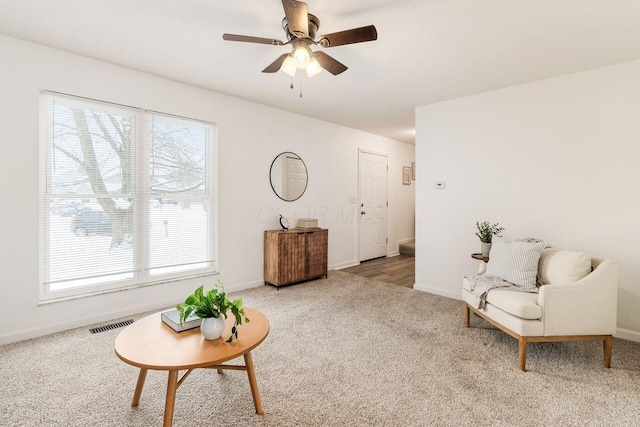 living area featuring carpet flooring and ceiling fan