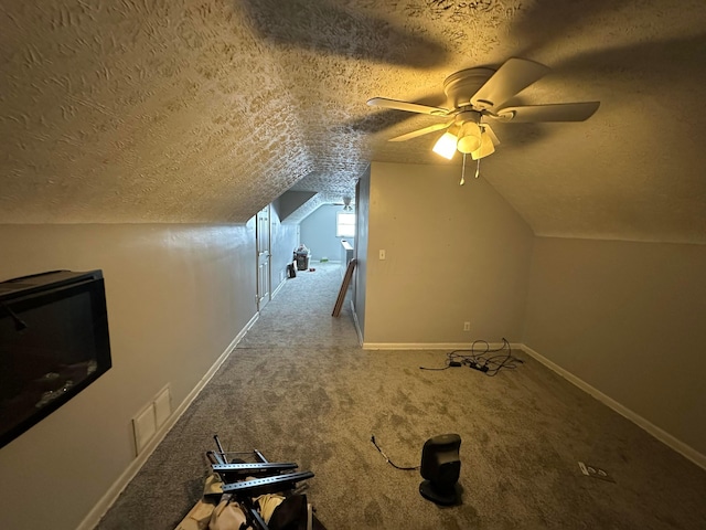 additional living space featuring ceiling fan, carpet floors, a textured ceiling, and lofted ceiling