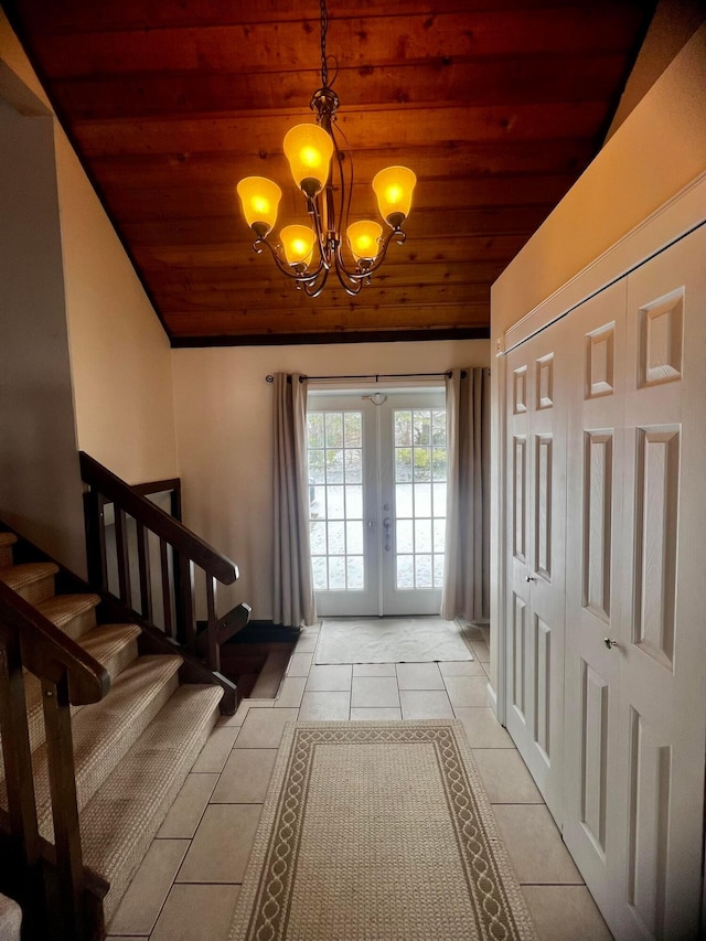 doorway to outside with french doors, wooden ceiling, light tile patterned flooring, and a chandelier