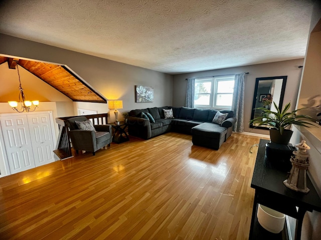 living room with a textured ceiling, hardwood / wood-style floors, and an inviting chandelier