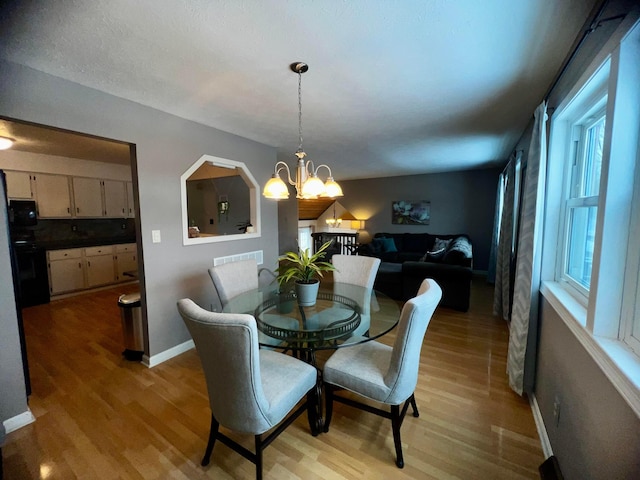 dining room with light hardwood / wood-style flooring and a chandelier