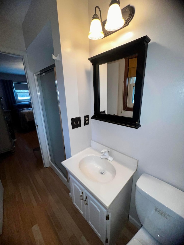 bathroom featuring toilet, a shower with door, vanity, and hardwood / wood-style flooring