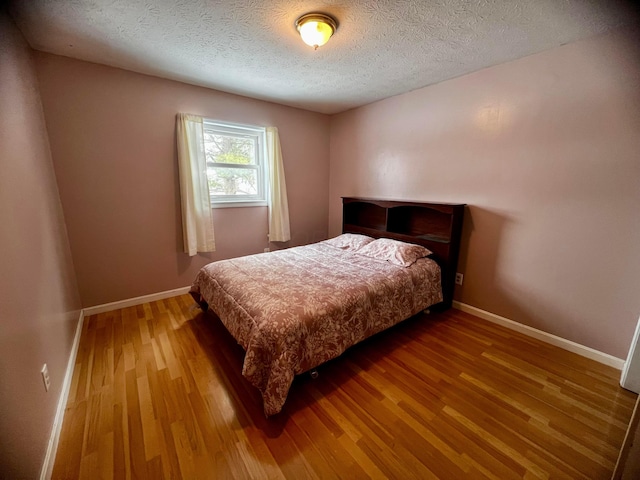 bedroom featuring a textured ceiling and hardwood / wood-style flooring