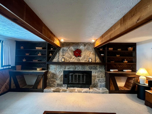 carpeted living room featuring a textured ceiling, built in features, and a stone fireplace