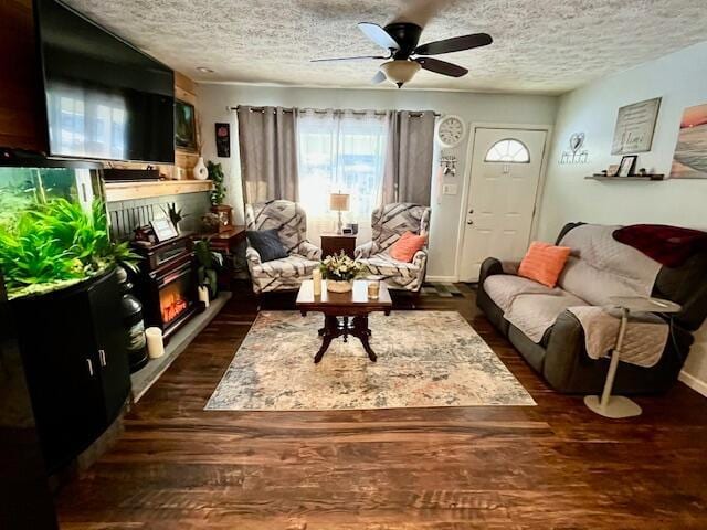 living room with ceiling fan, dark hardwood / wood-style floors, and a textured ceiling