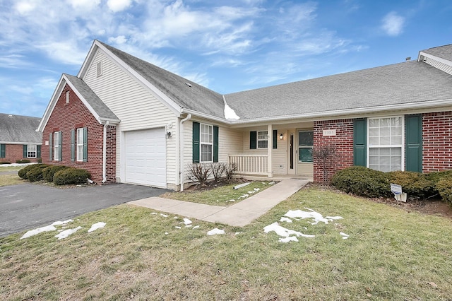 view of front of house with a garage, covered porch, and a front lawn