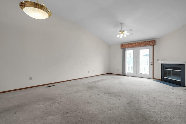 unfurnished living room with vaulted ceiling, light colored carpet, and ceiling fan