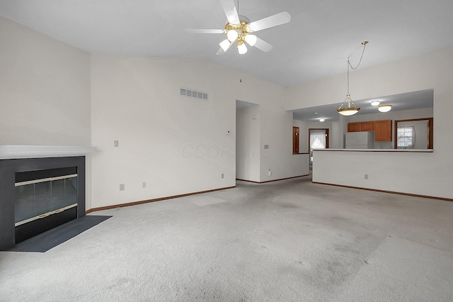 unfurnished living room featuring vaulted ceiling, light colored carpet, and ceiling fan