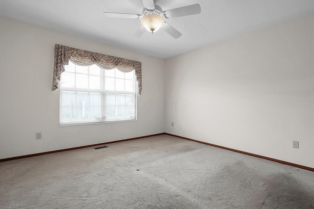 carpeted spare room with ceiling fan