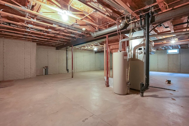 basement with gas water heater and brick wall