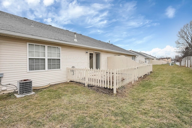 rear view of house featuring a lawn and central air condition unit