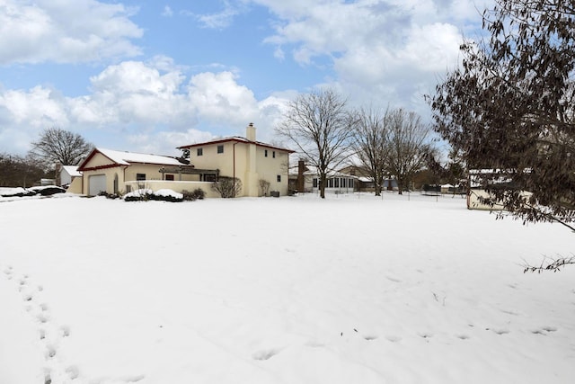 yard layered in snow featuring a garage