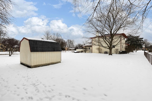 yard layered in snow featuring a storage unit