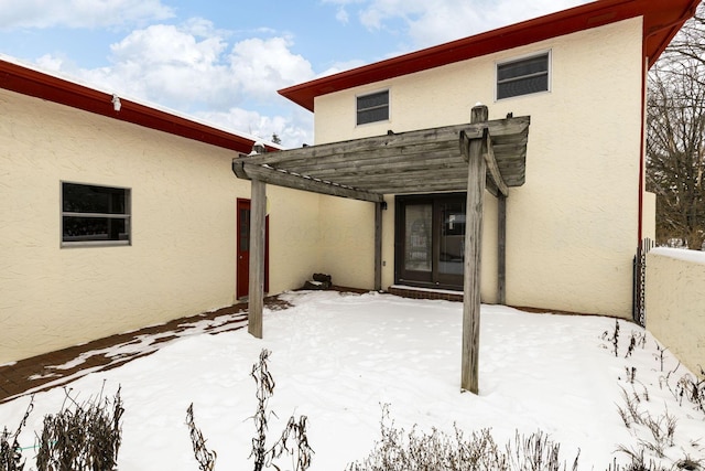 snow covered rear of property featuring a pergola