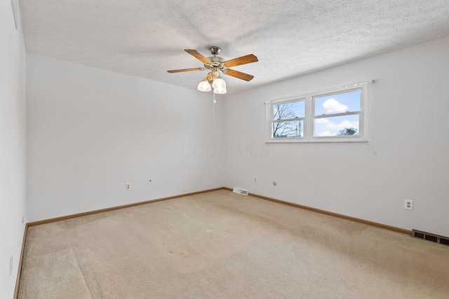 carpeted spare room featuring ceiling fan and a textured ceiling