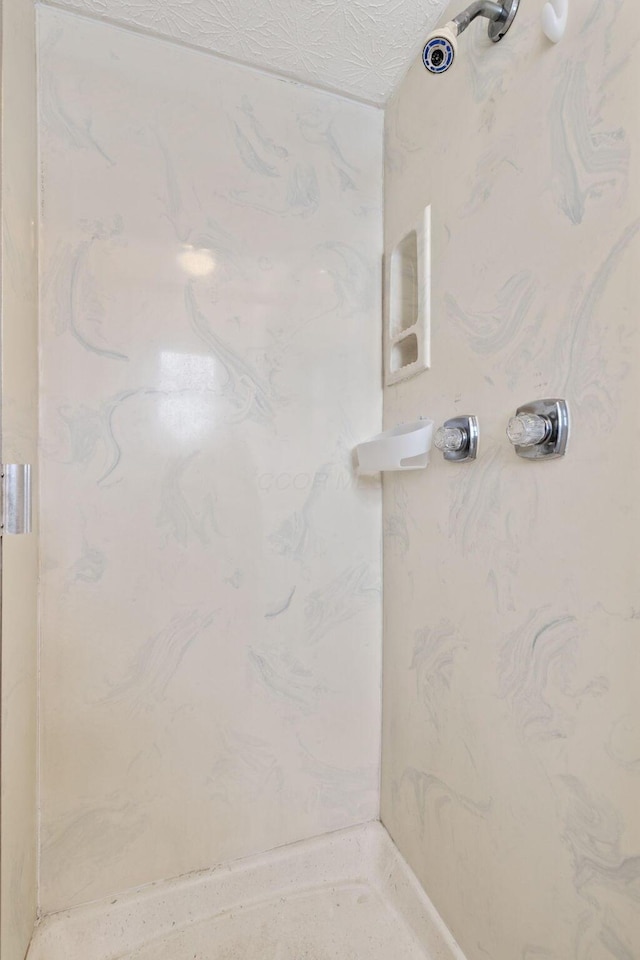 bathroom featuring a shower and a textured ceiling