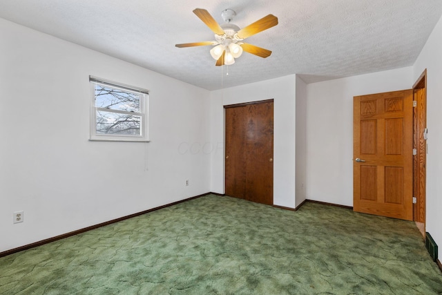 unfurnished bedroom with a closet, a textured ceiling, ceiling fan, and dark carpet