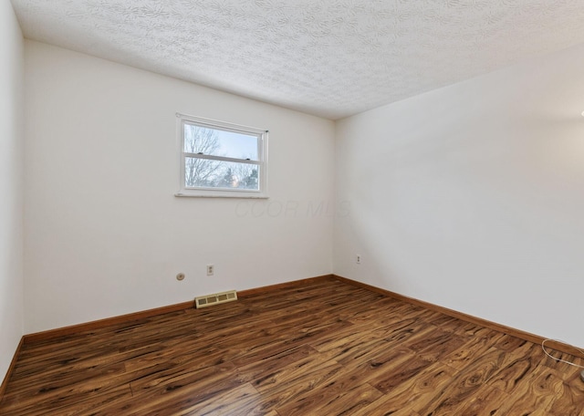 unfurnished room with dark hardwood / wood-style flooring and a textured ceiling