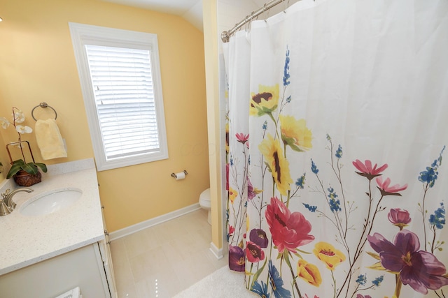 bathroom featuring vanity, toilet, curtained shower, and vaulted ceiling