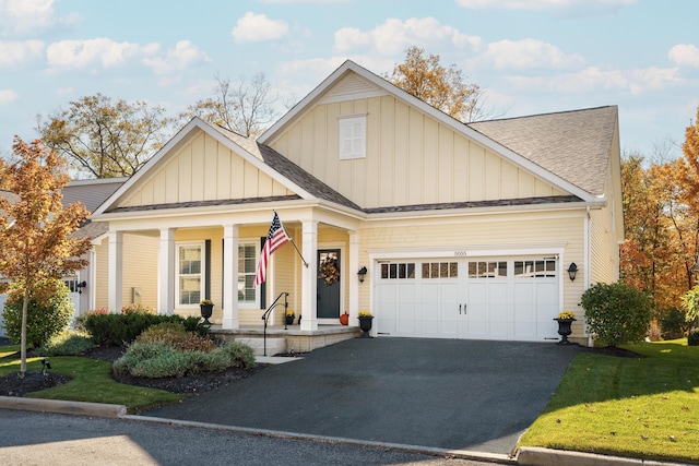 view of front of house with a porch, a garage, and a front yard