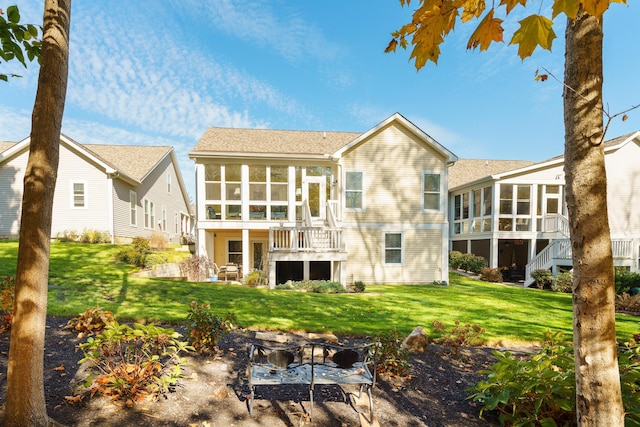 rear view of house featuring a sunroom, a yard, and a patio