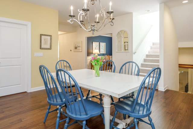 dining space with dark hardwood / wood-style flooring and a notable chandelier