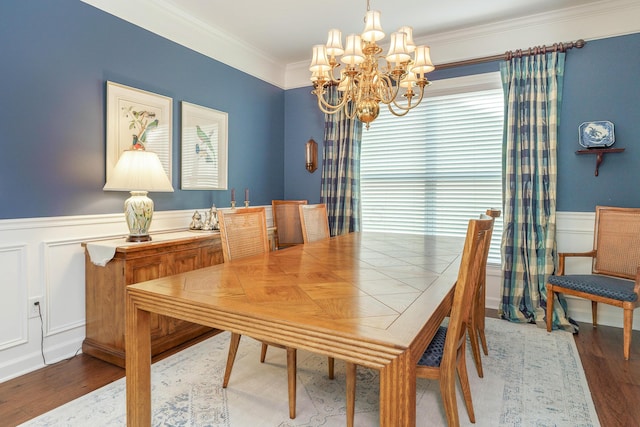 dining space featuring hardwood / wood-style flooring, ornamental molding, and a notable chandelier