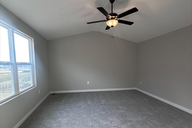 spare room featuring vaulted ceiling, ceiling fan, and carpet flooring