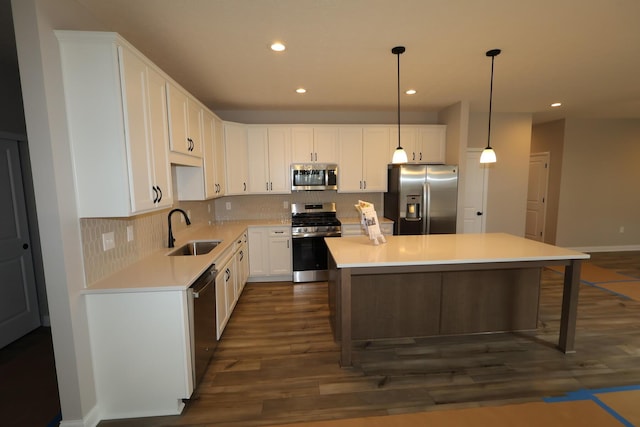 kitchen with a sink, stainless steel appliances, tasteful backsplash, and a center island