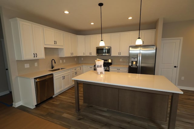 kitchen featuring tasteful backsplash, appliances with stainless steel finishes, dark wood-style floors, white cabinets, and a sink