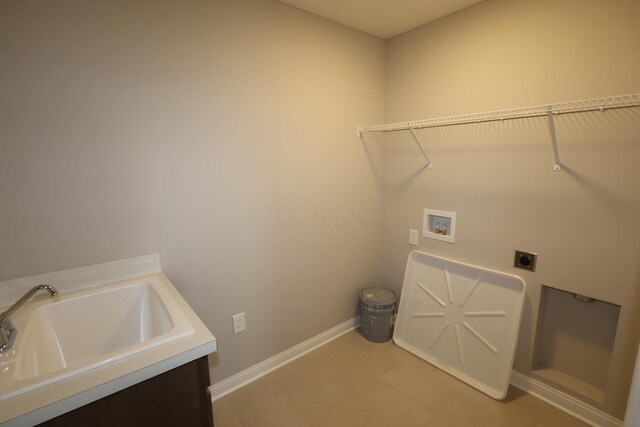 washroom featuring electric dryer hookup, a sink, baseboards, hookup for a washing machine, and laundry area