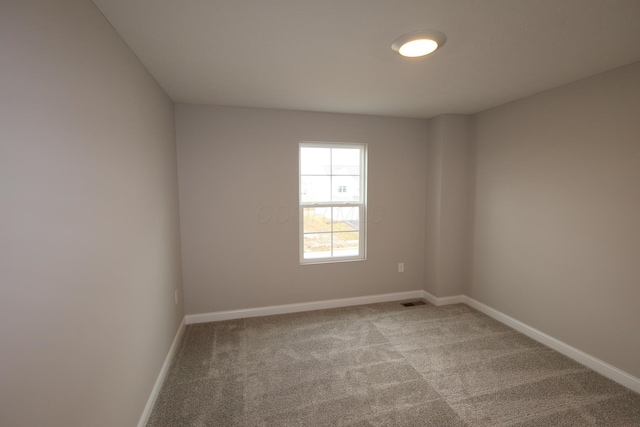 unfurnished room featuring visible vents, baseboards, and carpet