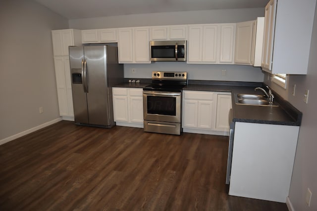 kitchen with appliances with stainless steel finishes, dark hardwood / wood-style floors, sink, and white cabinets