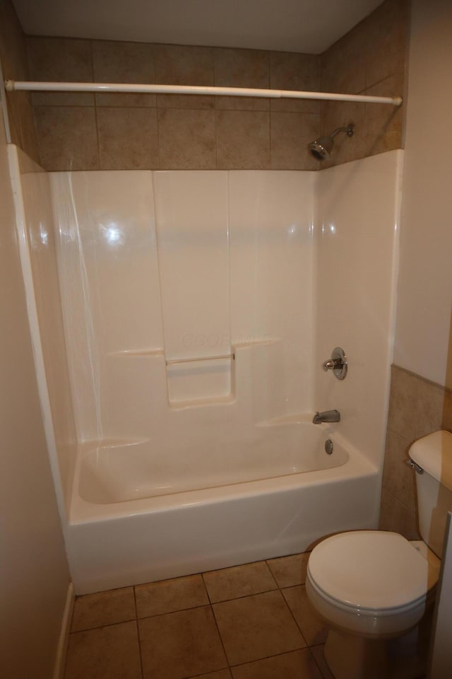 bathroom featuring tile patterned flooring, tub / shower combination, and toilet