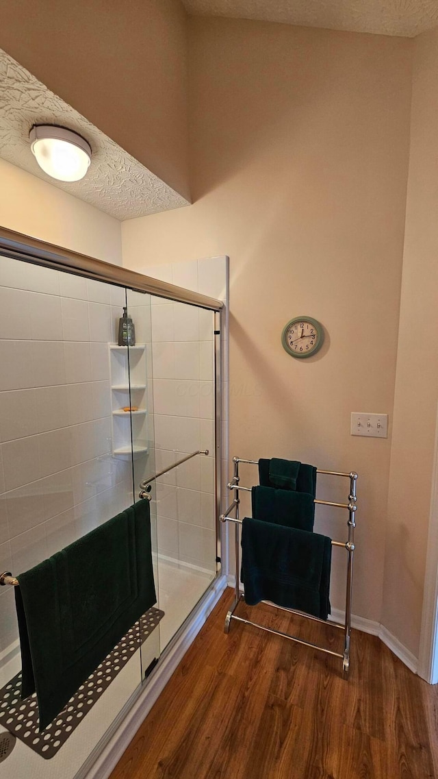 bathroom featuring hardwood / wood-style flooring, a textured ceiling, and walk in shower