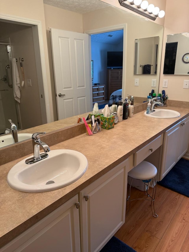 bathroom featuring vanity, walk in shower, and wood-type flooring