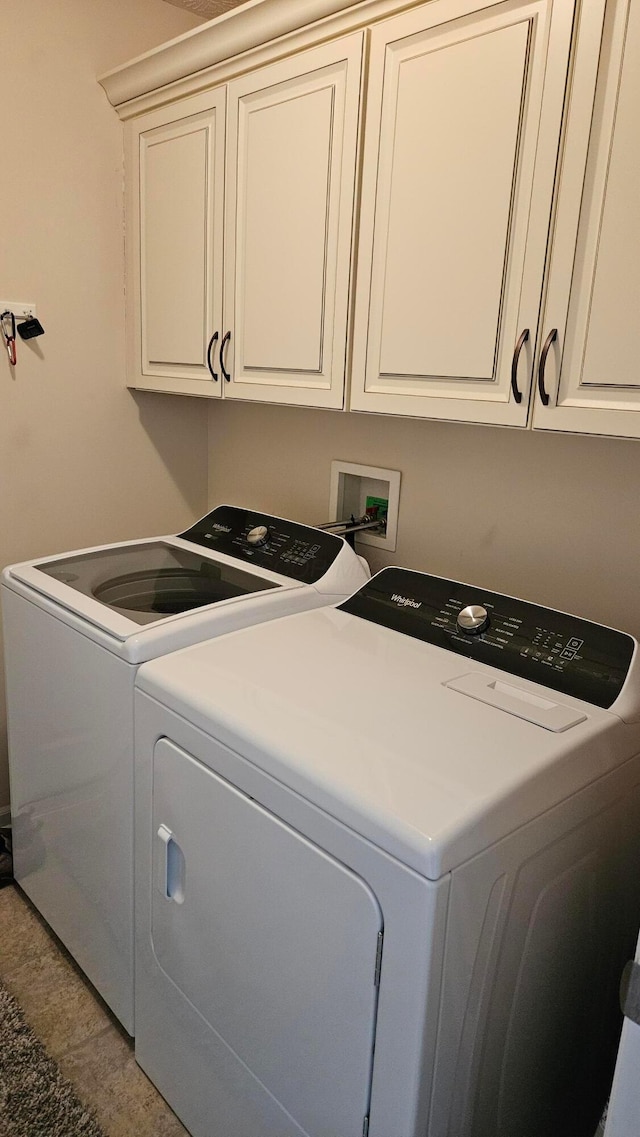 washroom with cabinets and washing machine and dryer