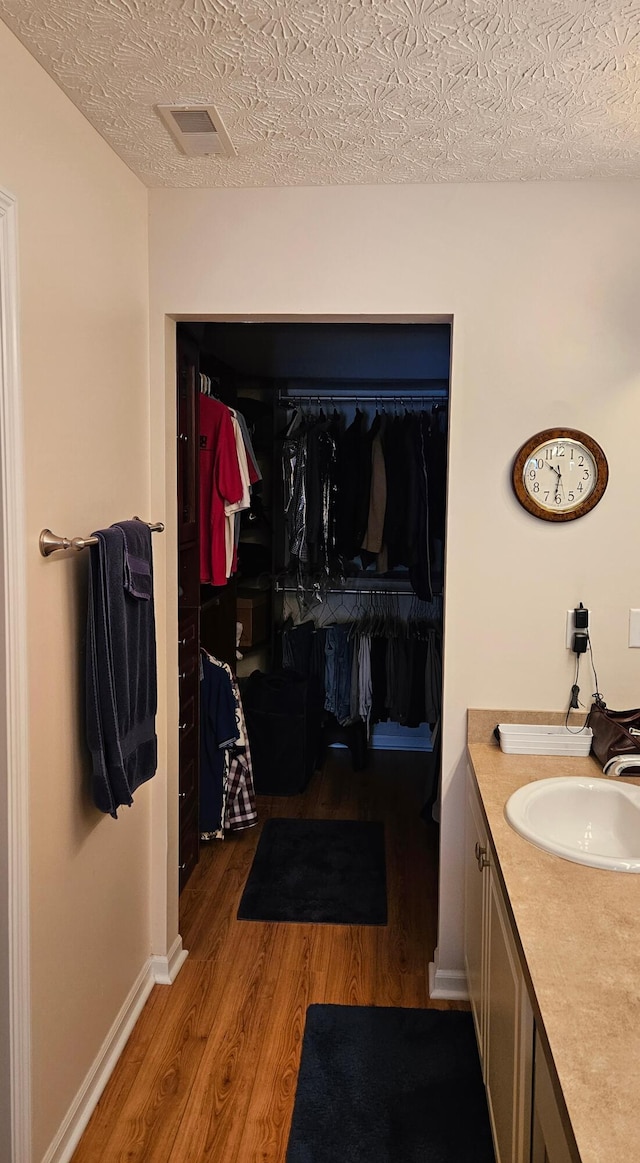 bathroom featuring vanity, a textured ceiling, and wood-type flooring