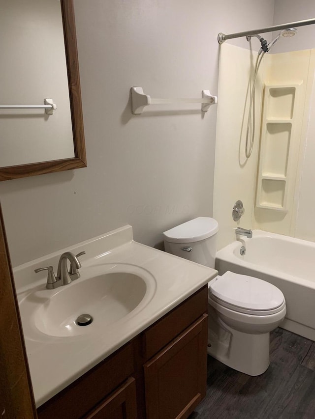 full bathroom featuring hardwood / wood-style floors, vanity, toilet, and shower / tub combination