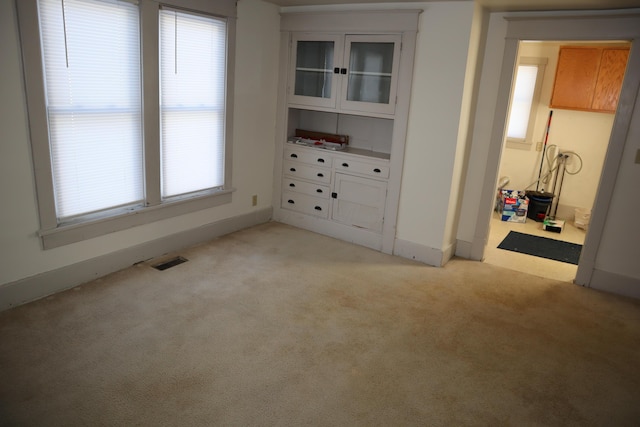 unfurnished bedroom with multiple windows and light colored carpet