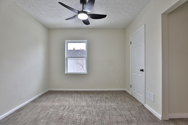 carpeted spare room featuring ceiling fan and a textured ceiling