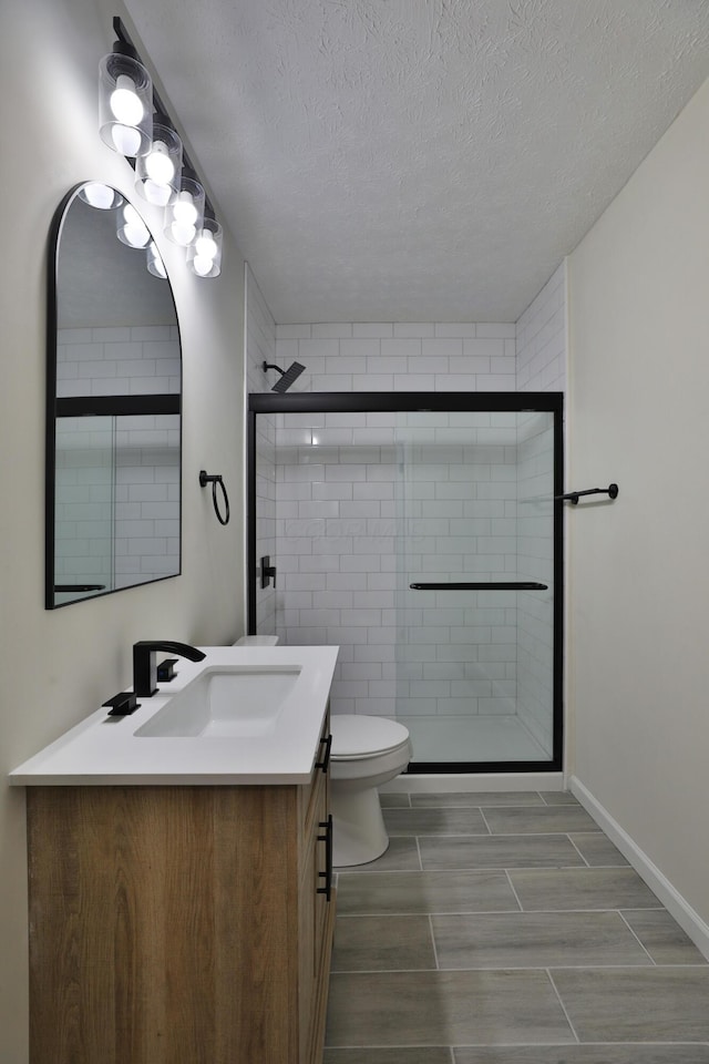 bathroom featuring vanity, an enclosed shower, and toilet