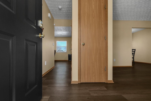 hallway featuring dark hardwood / wood-style flooring and a textured ceiling