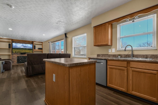 kitchen with a fireplace, a textured ceiling, sink, dishwasher, and a center island