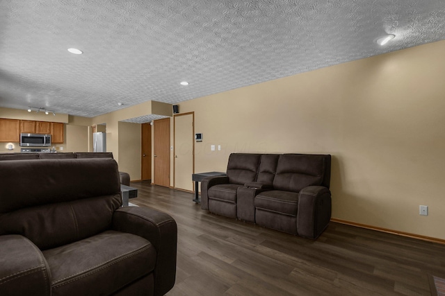 living room with rail lighting, dark hardwood / wood-style flooring, and a textured ceiling