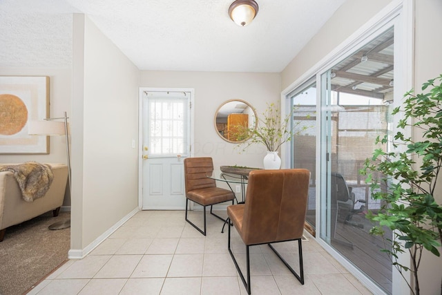 dining area featuring light tile patterned floors, a textured ceiling, and a healthy amount of sunlight